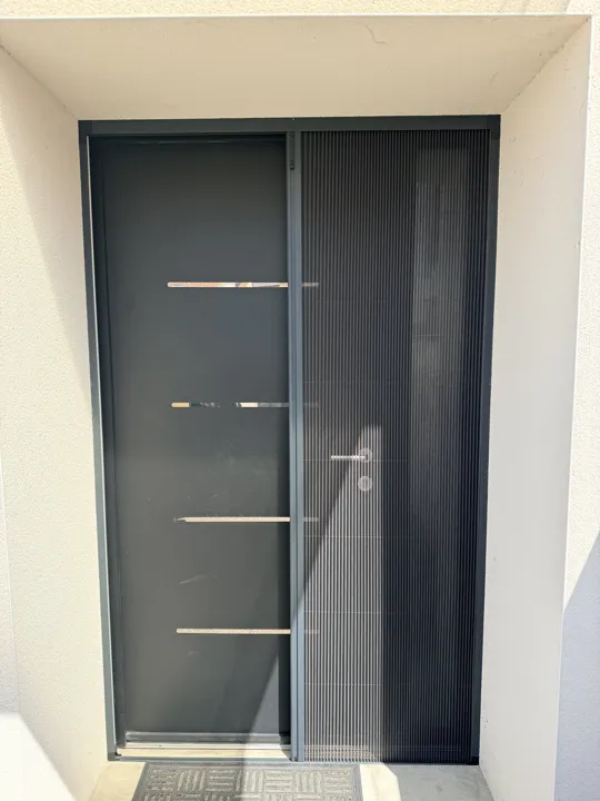 Moustiquaire plissée sur mesure posée sur une porte d'entrée